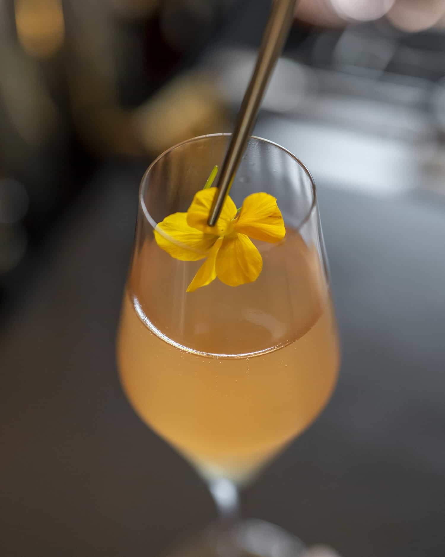 Cocktail with a yellow decorative flower in Bar 21 at Faubourg 21
